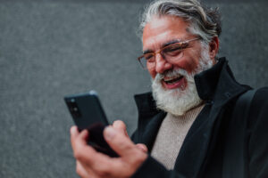 Portrait of a senior businessman using smartphone outside of the